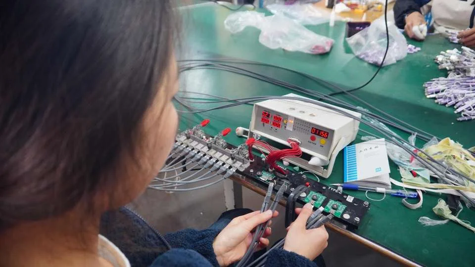 A person meticulously testing a USB cable with various devices