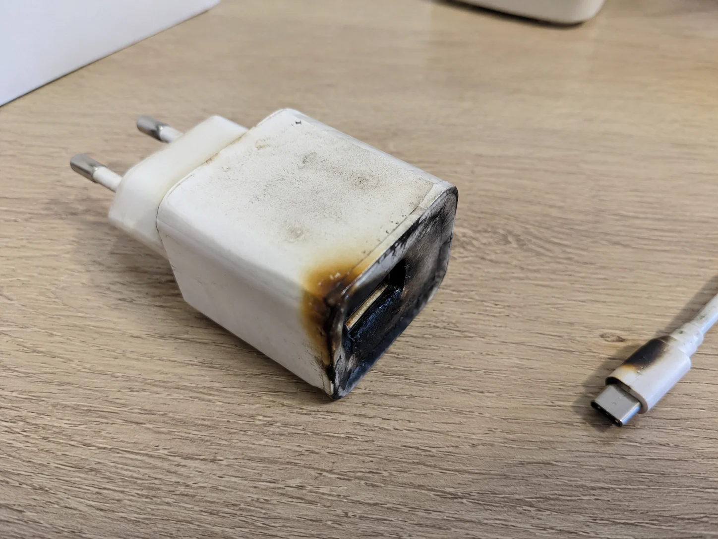 A photo of a burnt or damaged counterfeit charger